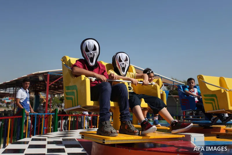 Palestinians take a ride at an amusement park on the third day of Eid al-Fitr holiday which marks the end of the Muslim holy month of Ramadan, in Gaza City on July 08, 2016. Photo by Ashraf Amra