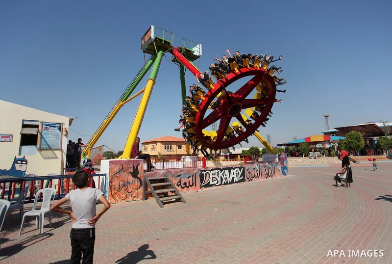 Palestinians take a ride at an amusement park on the third day of Eid al-Fitr holiday which marks the end of the Muslim holy month of Ramadan, in Gaza City on July 08, 2016. Photo by Ashraf Amra