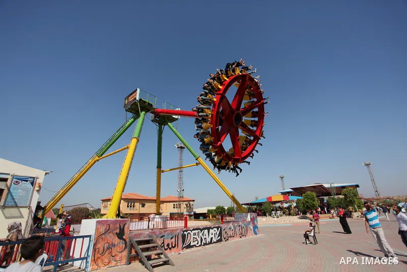 Palestinians take a ride at an amusement park on the third day of Eid al-Fitr holiday which marks the end of the Muslim holy month of Ramadan, in Gaza City on July 08, 2016. Photo by Ashraf Amra