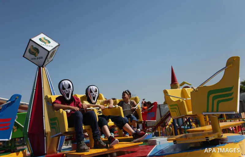 Palestinians take a ride at an amusement park on the third day of Eid al-Fitr holiday which marks the end of the Muslim holy month of Ramadan, in Gaza City on July 08, 2016. Photo by Ashraf Amra