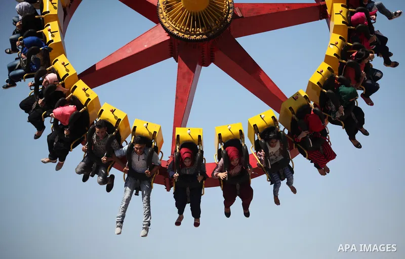 Palestinians take a ride at an amusement park on the third day of Eid al-Fitr holiday which marks the end of the Muslim holy month of Ramadan, in Gaza City on July 08, 2016. Photo by Ashraf Amra