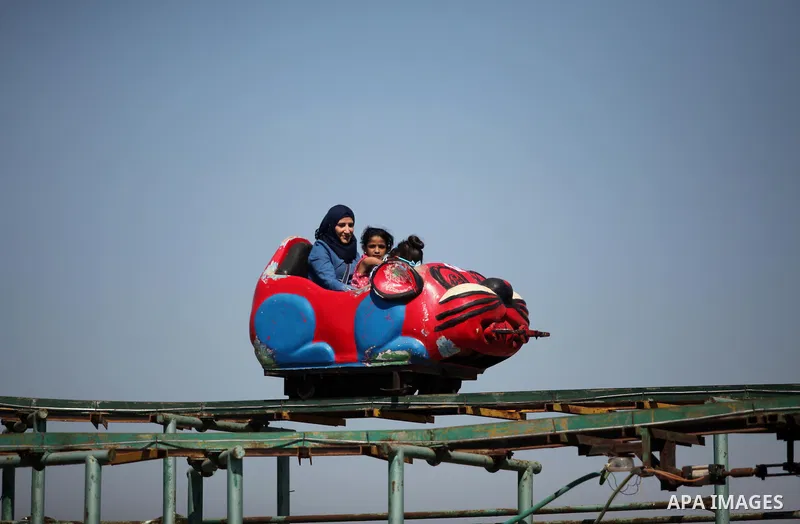 Palestinians take a ride at an amusement park on the third day of Eid al-Fitr holiday which marks the end of the Muslim holy month of Ramadan, in Gaza City on July 08, 2016. Photo by Ashraf Amra