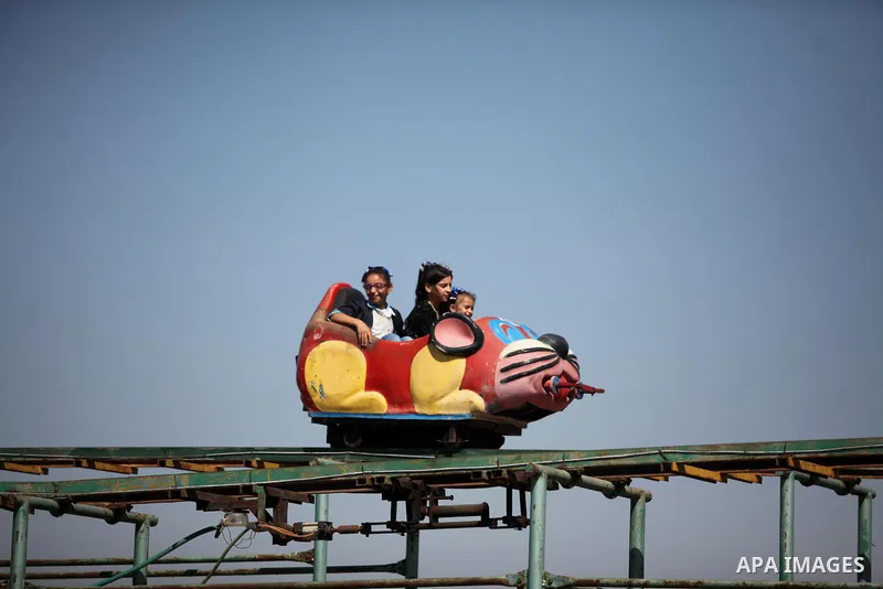 Palestinians take a ride at an amusement park on the third day of Eid al-Fitr holiday which marks the end of the Muslim holy month of Ramadan, in Gaza City on July 08, 2016. Photo by Ashraf Amra