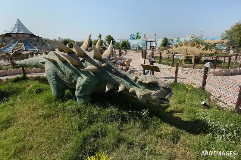 A Palestinian man watches a dinosaur model at an amusement park on the third day of Eid al-Fitr holiday which marks the end of the Muslim holy month of Ramadan, in Gaza City on July 08, 2016. Photo by Ashraf Amra