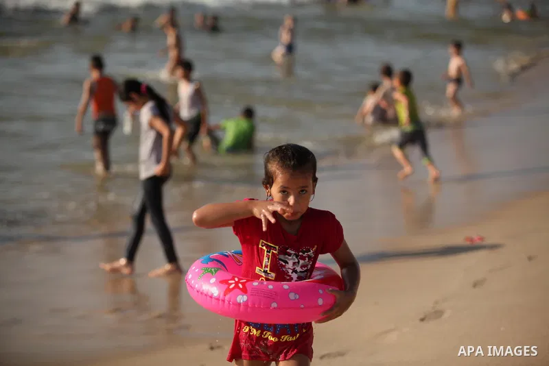 Palestinian children swim in the Mediterranean sea on the coast of Gaza city, on the third day of Eid al-Fitr holiday which marks the end of the Muslim holy month of Ramadan, on July 08, 2016. Photo by Ashraf Amra