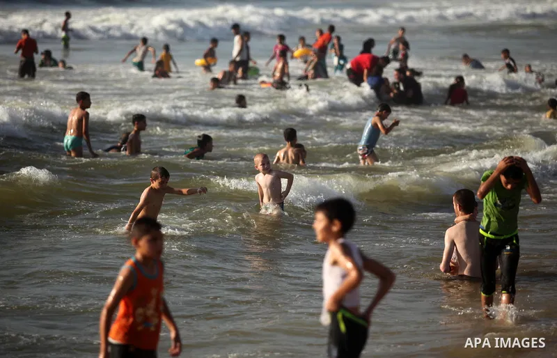 Palestinian children swim in the Mediterranean sea on the coast of Gaza city, on the third day of Eid al-Fitr holiday which marks the end of the Muslim holy month of Ramadan, on July 08, 2016. Photo by Ashraf Amra