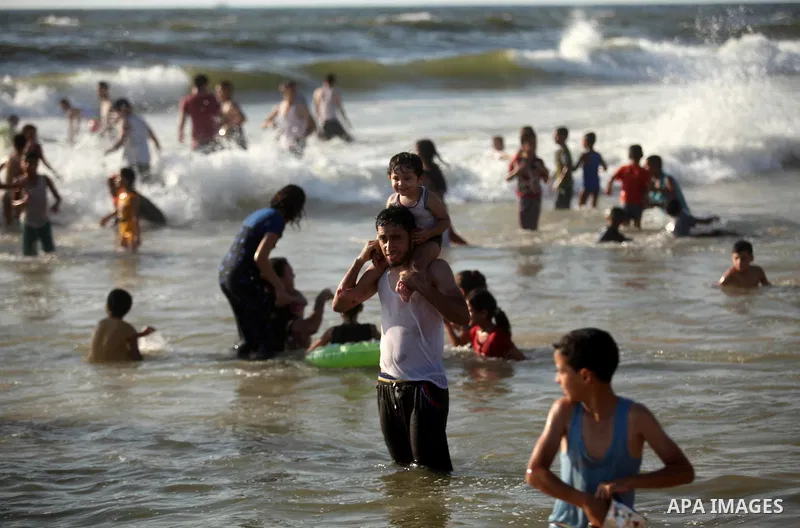 Palestinian children swim in the Mediterranean sea on the coast of Gaza city, on the third day of Eid al-Fitr holiday which marks the end of the Muslim holy month of Ramadan, on July 08, 2016. Photo by Ashraf Amra