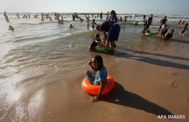 Palestinian children swim in the Mediterranean sea on the coast of Gaza city, on the third day of Eid al-Fitr holiday which marks the end of the Muslim holy month of Ramadan, on July 08, 2016. Photo by Ashraf Amra