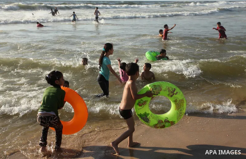 Palestinian children swim in the Mediterranean sea on the coast of Gaza city, on the third day of Eid al-Fitr holiday which marks the end of the Muslim holy month of Ramadan, on July 08, 2016. Photo by Ashraf Amra