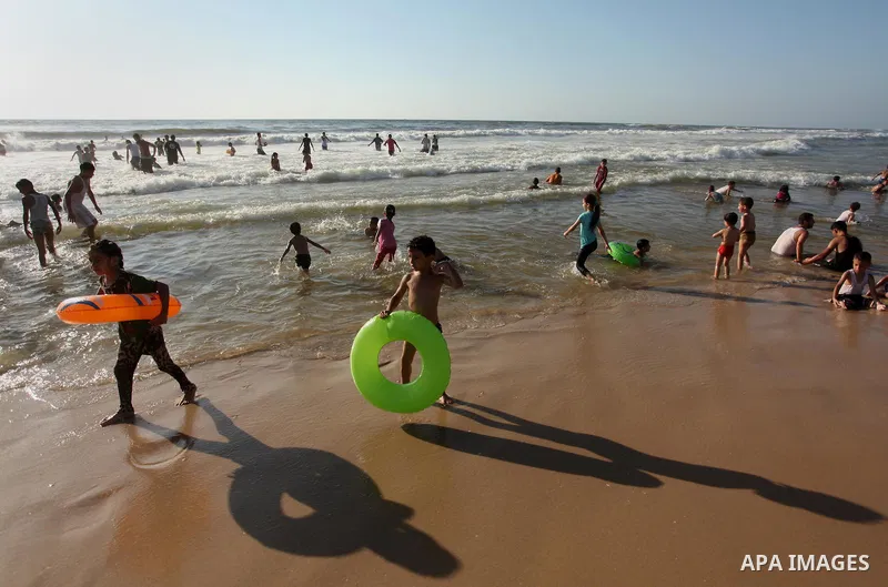 Palestinian children swim in the Mediterranean sea on the coast of Gaza city, on the third day of Eid al-Fitr holiday which marks the end of the Muslim holy month of Ramadan, on July 08, 2016. Photo by Ashraf Amra