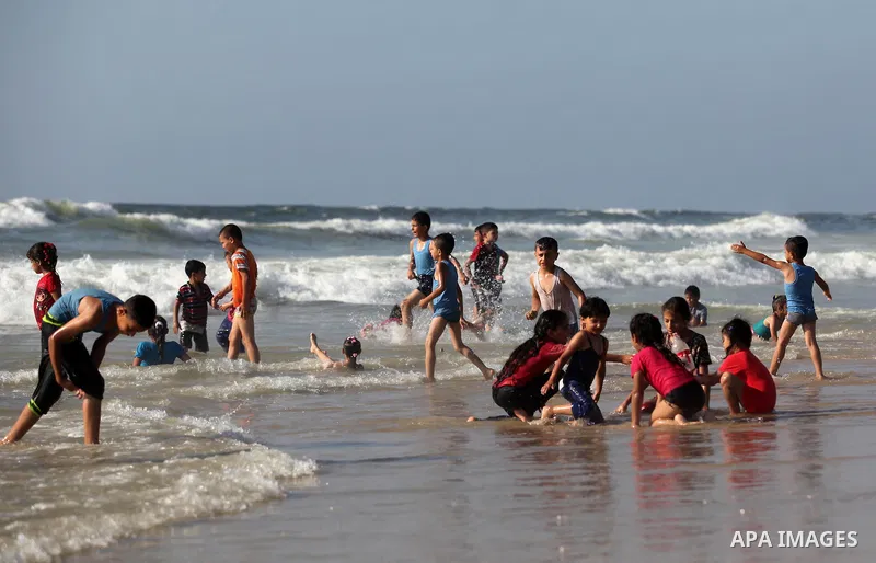 Palestinian children swim in the Mediterranean sea on the coast of Gaza city, on the third day of Eid al-Fitr holiday which marks the end of the Muslim holy month of Ramadan, on July 08, 2016. Photo by Ashraf Amra