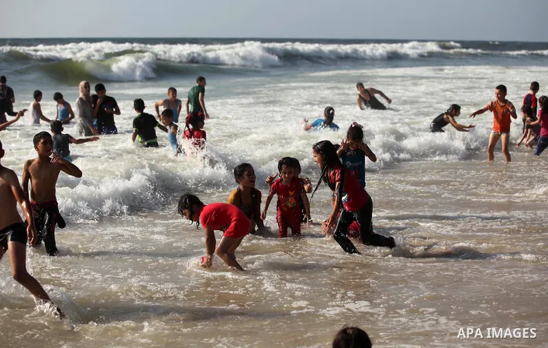 Palestinian children swim in the Mediterranean sea on the coast of Gaza city, on the third day of Eid al-Fitr holiday which marks the end of the Muslim holy month of Ramadan, on July 08, 2016. Photo by Ashraf Amra