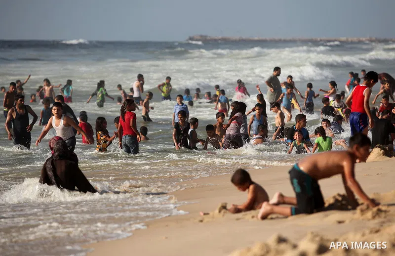 Palestinian children swim in the Mediterranean sea on the coast of Gaza city, on the third day of Eid al-Fitr holiday which marks the end of the Muslim holy month of Ramadan, on July 08, 2016. Photo by Ashraf Amra