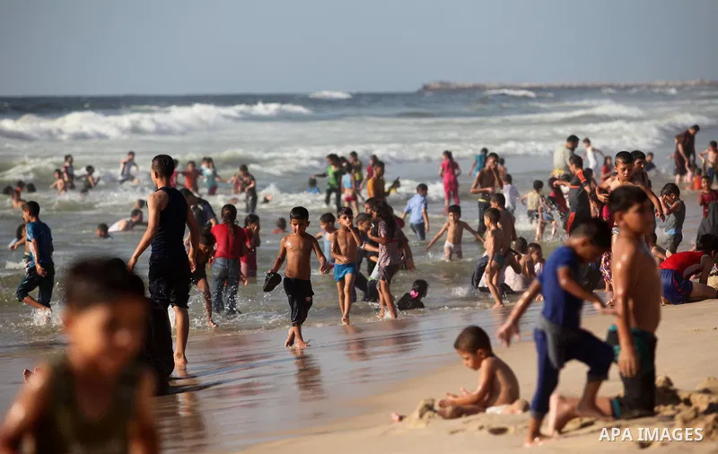 Palestinian children swim in the Mediterranean sea on the coast of Gaza city, on the third day of Eid al-Fitr holiday which marks the end of the Muslim holy month of Ramadan, on July 08, 2016. Photo by Ashraf Amra