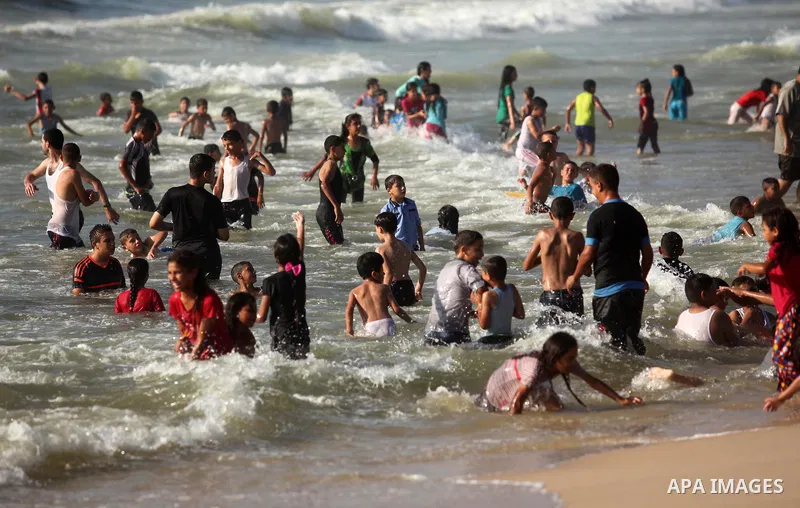 Palestinian children swim in the Mediterranean sea on the coast of Gaza city, on the third day of Eid al-Fitr holiday which marks the end of the Muslim holy month of Ramadan, on July 08, 2016. Photo by Ashraf Amra