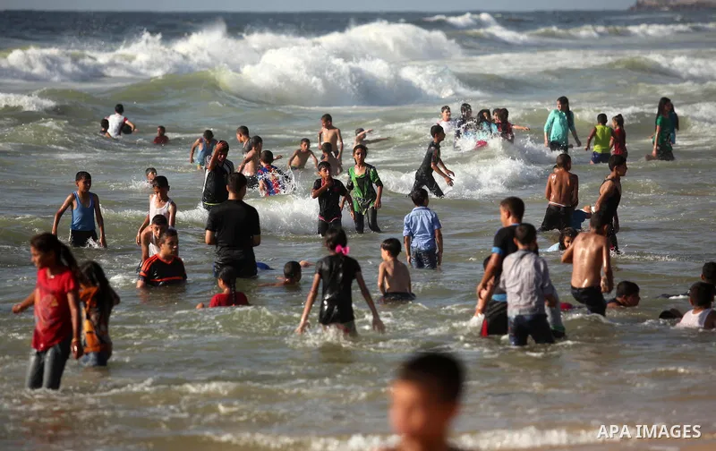 Palestinian children swim in the Mediterranean sea on the coast of Gaza city, on the third day of Eid al-Fitr holiday which marks the end of the Muslim holy month of Ramadan, on July 08, 2016. Photo by Ashraf Amra