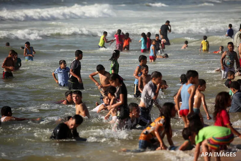 Palestinian children swim in the Mediterranean sea on the coast of Gaza city, on the third day of Eid al-Fitr holiday which marks the end of the Muslim holy month of Ramadan, on July 08, 2016. Photo by Ashraf Amra