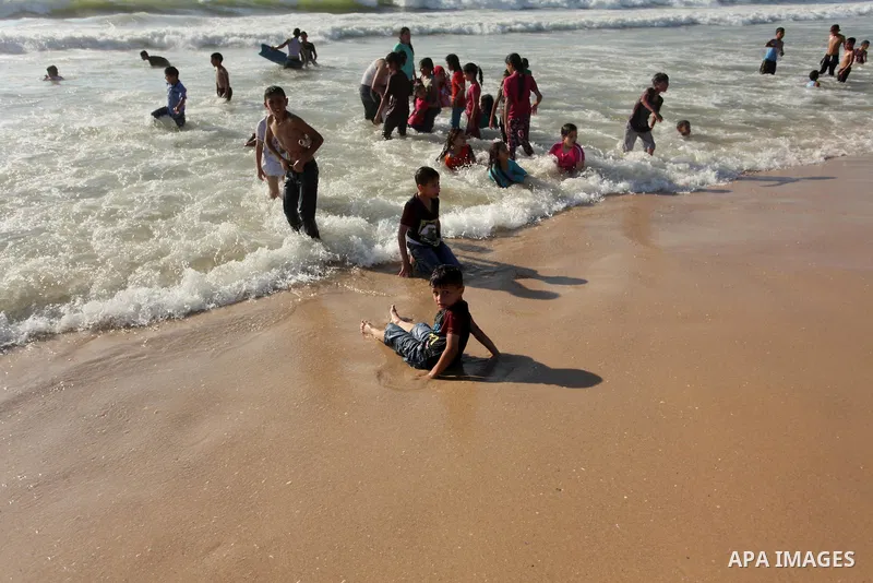 Palestinian children swim in the Mediterranean sea on the coast of Gaza city, on the third day of Eid al-Fitr holiday which marks the end of the Muslim holy month of Ramadan, on July 08, 2016. Photo by Ashraf Amra