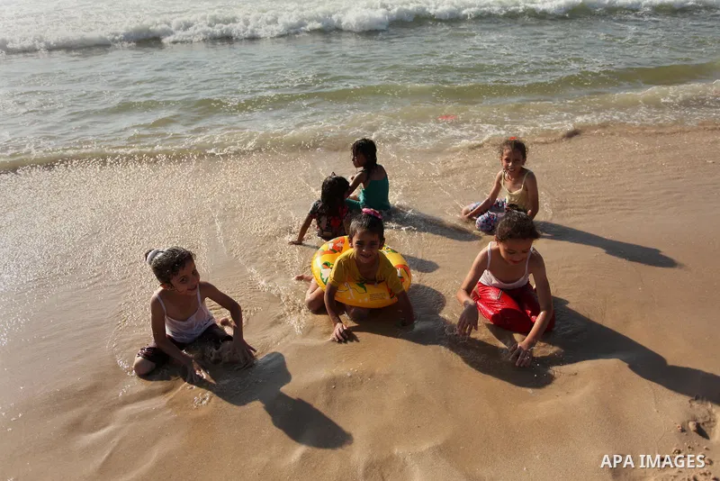 Palestinian children swim in the Mediterranean sea on the coast of Gaza city, on the third day of Eid al-Fitr holiday which marks the end of the Muslim holy month of Ramadan, on July 08, 2016. Photo by Ashraf Amra