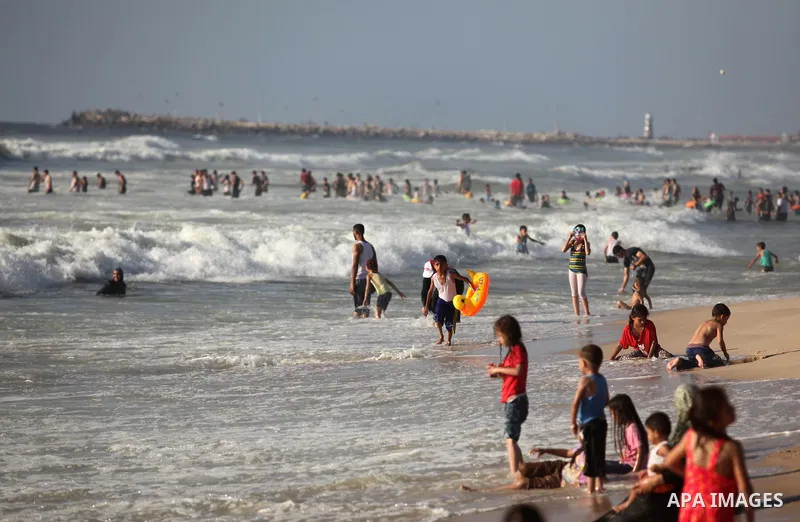 Palestinian children swim in the Mediterranean sea on the coast of Gaza city, on the third day of Eid al-Fitr holiday which marks the end of the Muslim holy month of Ramadan, on July 08, 2016. Photo by Ashraf Amra