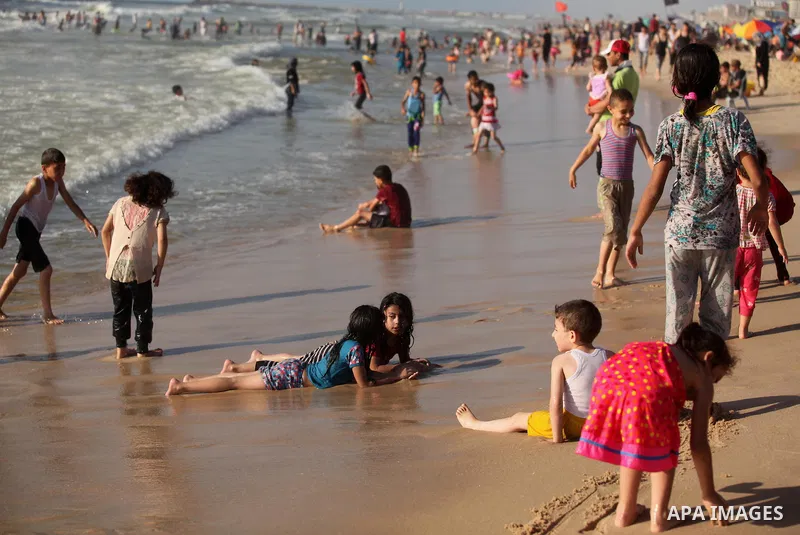 Palestinian children swim in the Mediterranean sea on the coast of Gaza city, on the third day of Eid al-Fitr holiday which marks the end of the Muslim holy month of Ramadan, on July 08, 2016. Photo by Ashraf Amra
