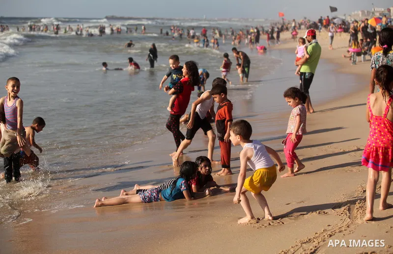 Palestinian children swim in the Mediterranean sea on the coast of Gaza city, on the third day of Eid al-Fitr holiday which marks the end of the Muslim holy month of Ramadan, on July 08, 2016. Photo by Ashraf Amra