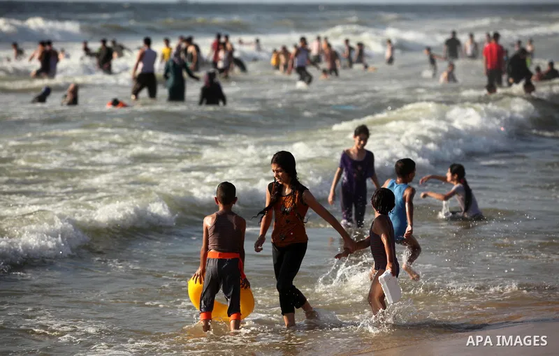 Palestinian children swim in the Mediterranean sea on the coast of Gaza city, on the third day of Eid al-Fitr holiday which marks the end of the Muslim holy month of Ramadan, on July 08, 2016. Photo by Ashraf Amra