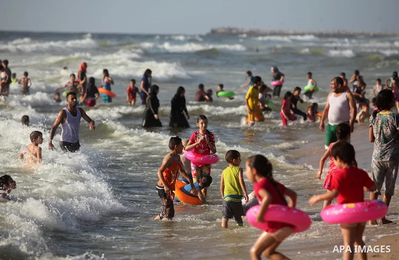 Palestinian children swim in the Mediterranean sea on the coast of Gaza city, on the third day of Eid al-Fitr holiday which marks the end of the Muslim holy month of Ramadan, on July 08, 2016. Photo by Ashraf Amra