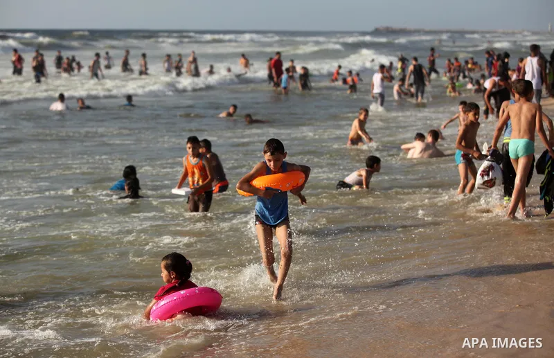 Palestinian children swim in the Mediterranean sea on the coast of Gaza city, on the third day of Eid al-Fitr holiday which marks the end of the Muslim holy month of Ramadan, on July 08, 2016. Photo by Ashraf Amra