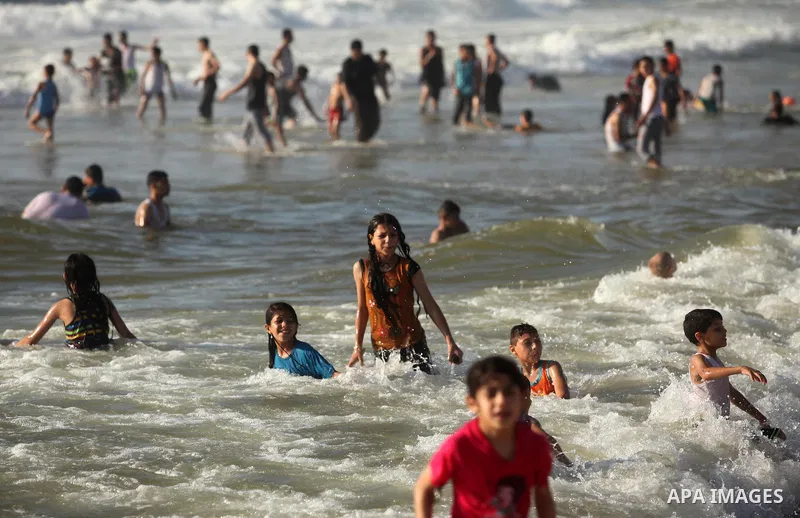 Palestinian children swim in the Mediterranean sea on the coast of Gaza city, on the third day of Eid al-Fitr holiday which marks the end of the Muslim holy month of Ramadan, on July 08, 2016. Photo by Ashraf Amra