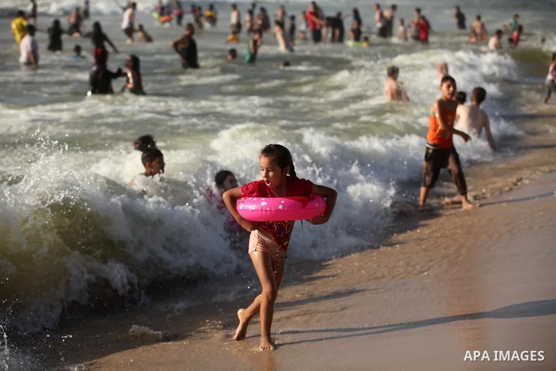 Palestinian children swim in the Mediterranean sea on the coast of Gaza city, on the third day of Eid al-Fitr holiday which marks the end of the Muslim holy month of Ramadan, on July 08, 2016. Photo by Ashraf Amra
