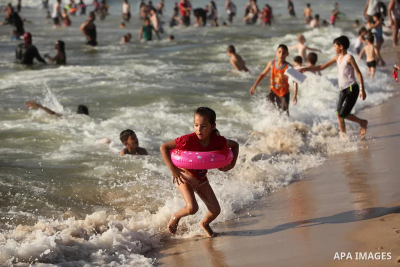 Palestinian children swim in the Mediterranean sea on the coast of Gaza city, on the third day of Eid al-Fitr holiday which marks the end of the Muslim holy month of Ramadan, on July 08, 2016. Photo by Ashraf Amra