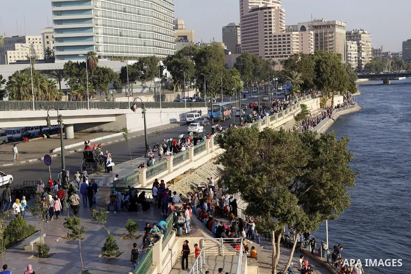 Egyptians walk past Nile River on the third day of Eid al-Fitr holiday which marks the end of the Muslim holy month of Ramadan, in Cairo, Egypt, on July 08, 2016. Photo by Amr Sayed