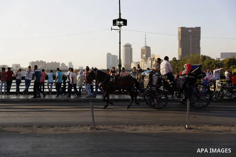 Egyptians walk past Nile River on the third day of Eid al-Fitr holiday which marks the end of the Muslim holy month of Ramadan, in Cairo, Egypt, on July 08, 2016. Photo by Amr Sayed