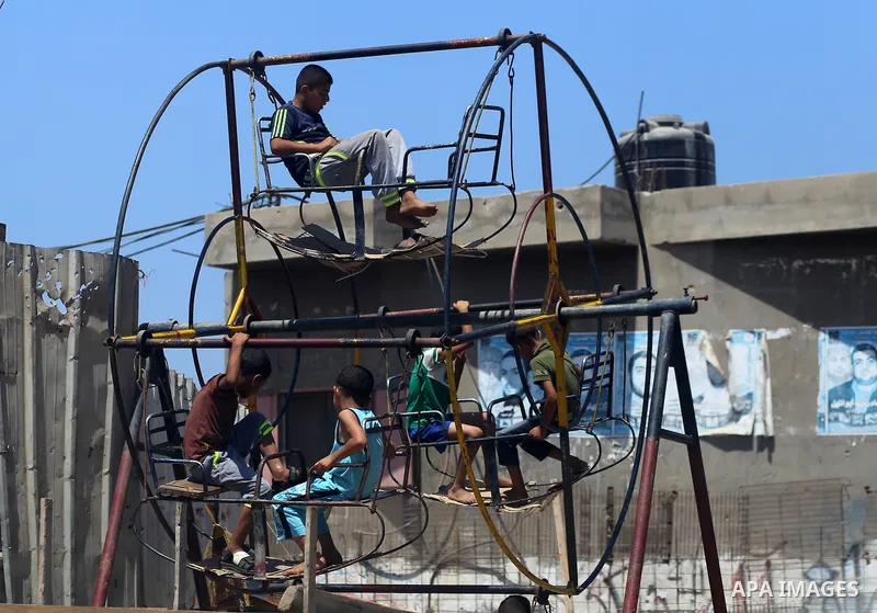 Palestinian children play in front of the houses, which was damaged during the 50-day Israeli war on Gaza Strip last summer, in Shejaiya neighborhood in Gaza city July 9, 2016. July 8th marks the two-year anniversary of...
