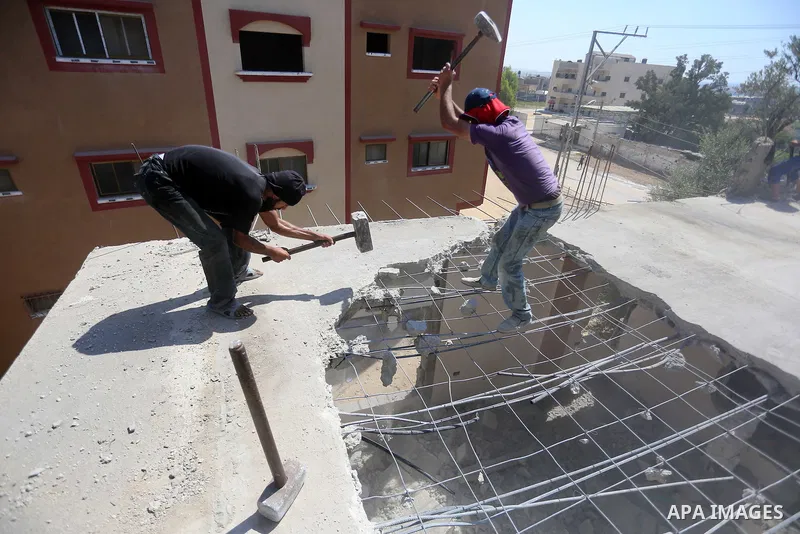 Palestinian construction workers work at the house, to marking the second anniversary of the 50-day Israeli war on Gaza Strip last summer, in Shejaiya neighborhood in Gaza city July 9, 2016. July 8th marks the two-year a...