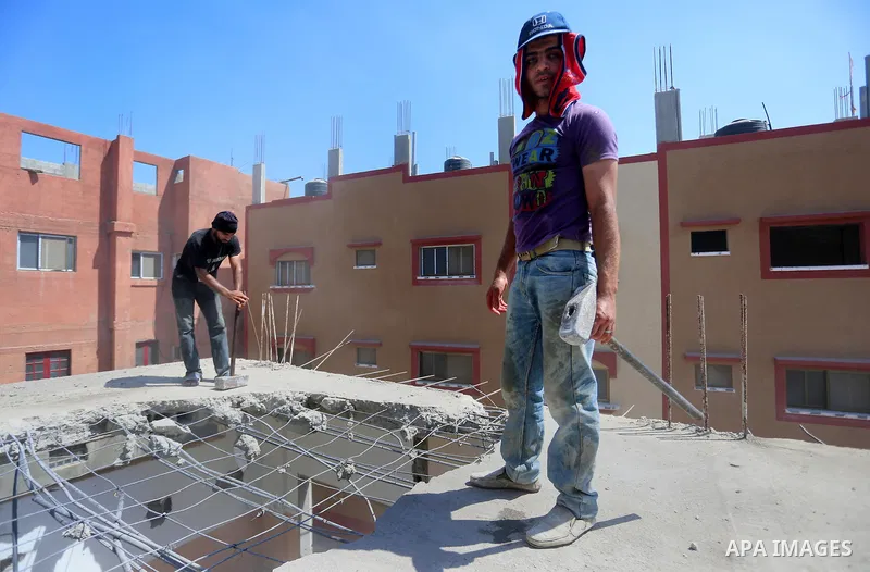 Palestinian construction workers work at the house, to marking the second anniversary of the 50-day Israeli war on Gaza Strip last summer, in Shejaiya neighborhood in Gaza city July 9, 2016. July 8th marks the two-year a...