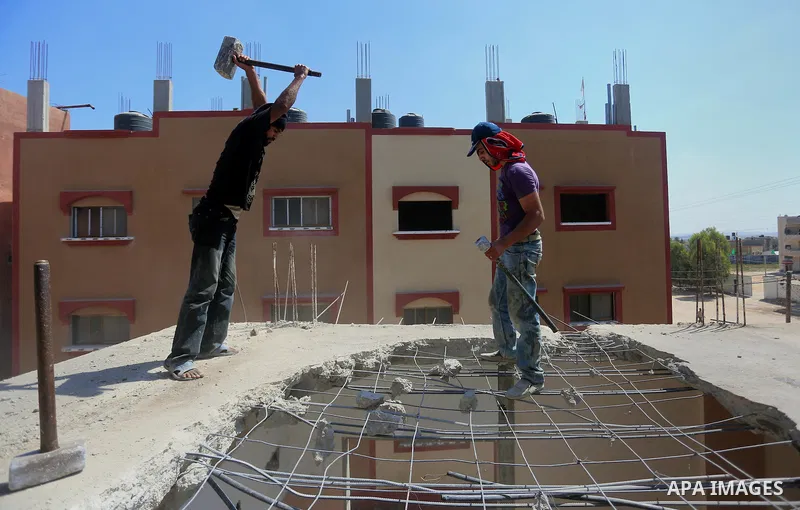 Palestinian construction workers work at the house, to marking the second anniversary of the 50-day Israeli war on Gaza Strip last summer, in Shejaiya neighborhood in Gaza city July 9, 2016. July 8th marks the two-year a...