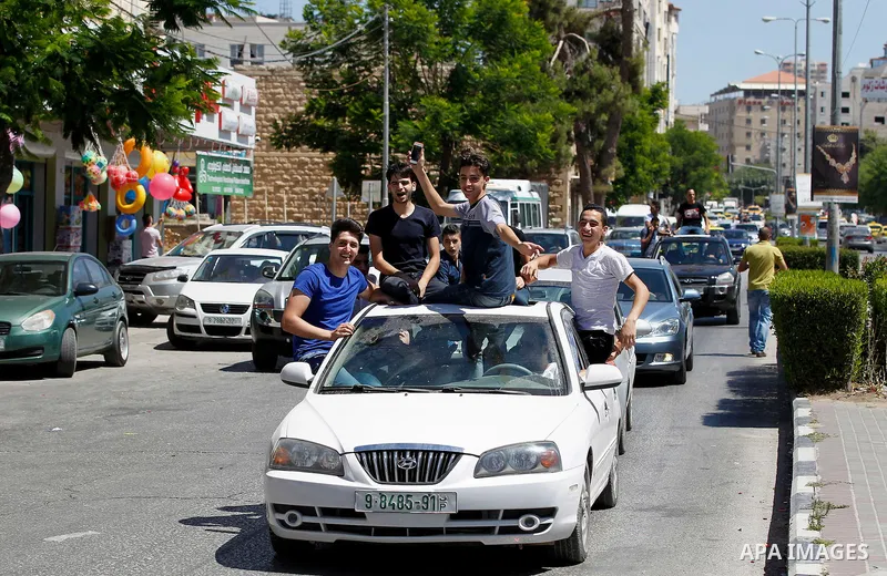 Palestinian high school students celebrate after heard their results of final exams known as "Tawjihi", in the West Bank city of Hebron on July 11, 2016. Photo by Wisam Hashlamoun
