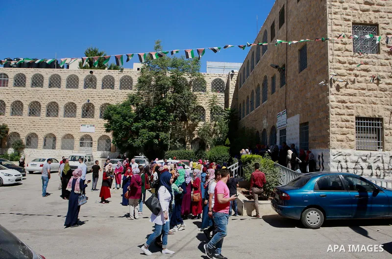 Palestinian high school students celebrate after heard their results of final exams known as "Tawjihi", in the West Bank city of Hebron on July 11, 2016. Photo by Wisam Hashlamoun