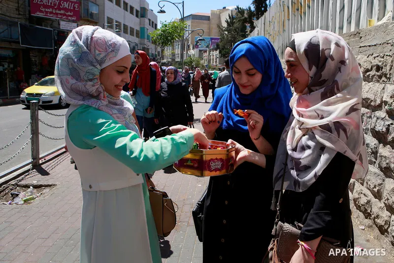 Palestinian high school students celebrate after heard their results of final exams known as "Tawjihi", in the West Bank city of Hebron on July 11, 2016. Photo by Wisam Hashlamoun