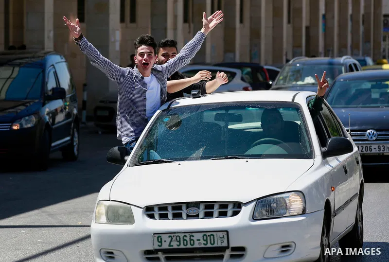 Palestinian high school students celebrate after heard their results of final exams known as "Tawjihi", in the West Bank city of Hebron on July 11, 2016. Photo by Wisam Hashlamoun