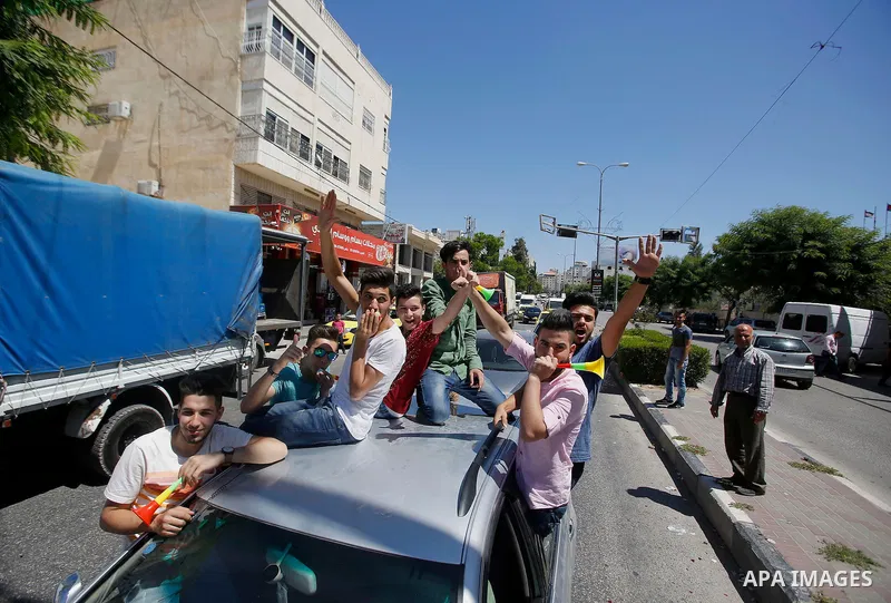 Palestinian high school students celebrate after heard their results of final exams known as "Tawjihi", in the West Bank city of Hebron on July 11, 2016. Photo by Wisam Hashlamoun