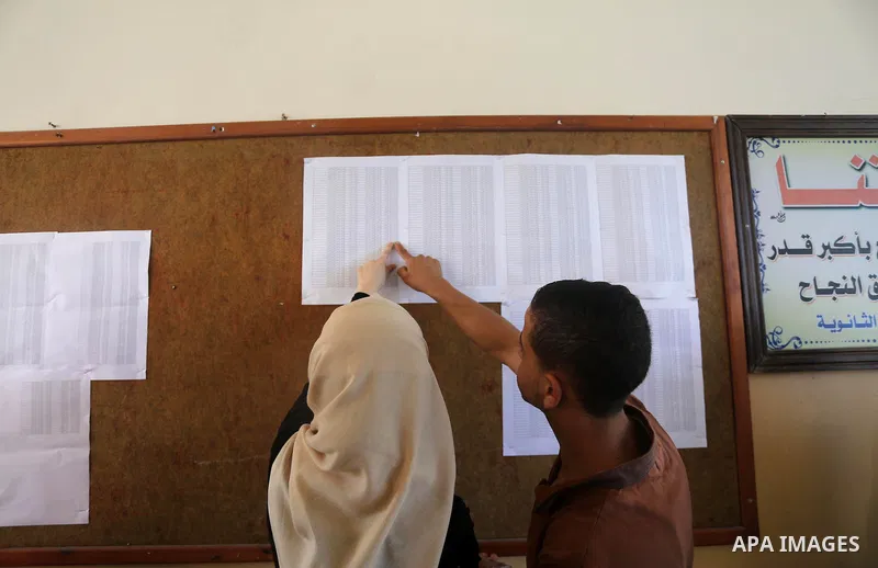 Palestinian high school students look for their results of final high school exams, known as "Tawjihi" in Gaza city on July 11, 2016. Photo by Mohammed Asad