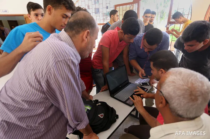 Palestinian high school students look for their results of final high school exams, known as "Tawjihi" in Gaza city on July 11, 2016. Photo by Mohammed Asad