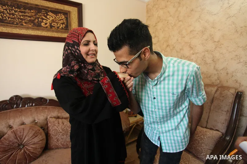 A Palestinian high school student, Mohammed Walid Haddad 99.6, celebrates with his family after heard the results of her final exams known as ''Tawjihi'', in the Gaza city, on July 11, 2016. Photo by Ashraf Amra