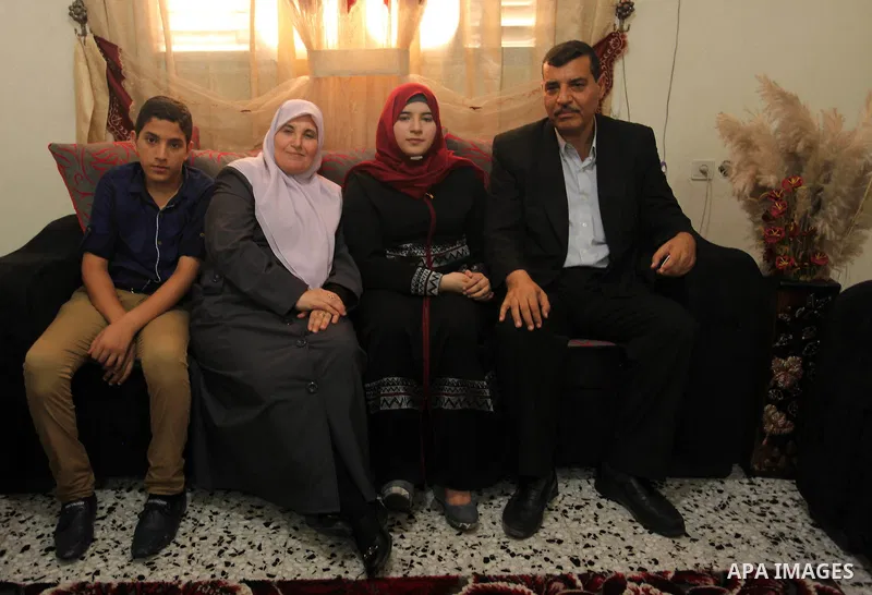 A Palestinian high school student,Amani Mohammed Shatat 99.6, celebrates with her family after heard the results of her final exams known as ''Tawjihi'', in the Gaza city, on July 11, 2016. Photo by Ashraf Amra