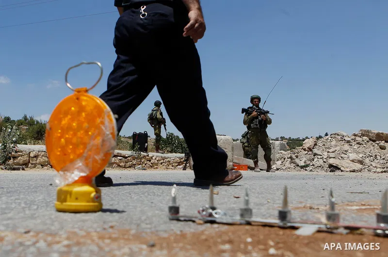 A Palestinian man gets round a roadblock, on July 11, 2016 in the West Bank village of Sair, east of Hebron, as the army keeps the area under lockdown afer an Israeli man was shot and wounded while driving his car near t...
