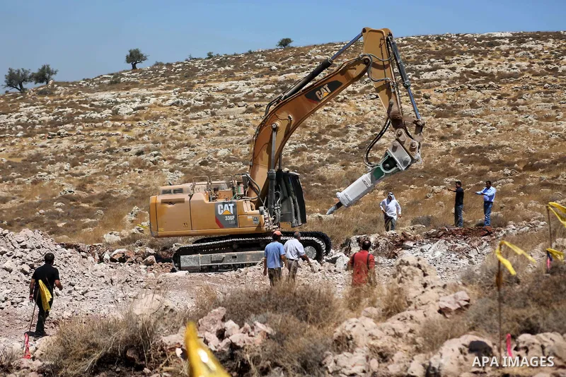 Palestinians try to prevent Israeli excavator from clearing their land during a protest against Jewish settlements, near the village of Deir Qaddis near the West Bank city of Ramallah July 13, 2016. Photo by Shadi Hatem