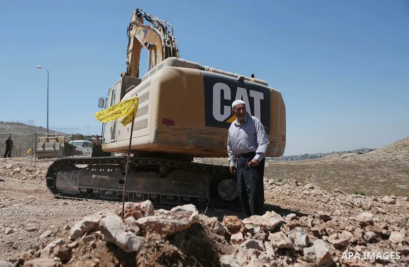 A Palestinian man tries to prevent Israeli excavator from clearing his land during a protest against Jewish settlements, near the village of Deir Qaddis near the West Bank city of Ramallah July 13, 2016. Photo by Shadi H...